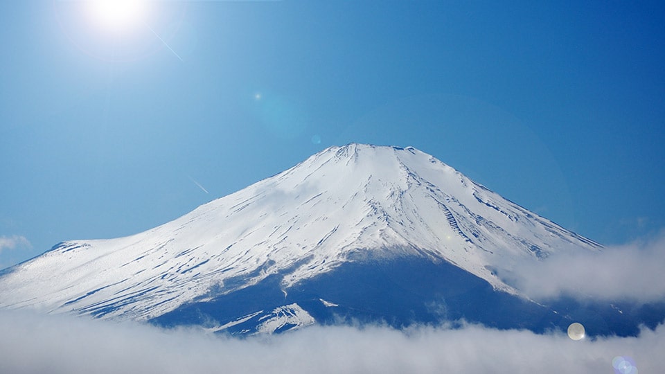 雪が積もった富士山と、その下に広がる雲