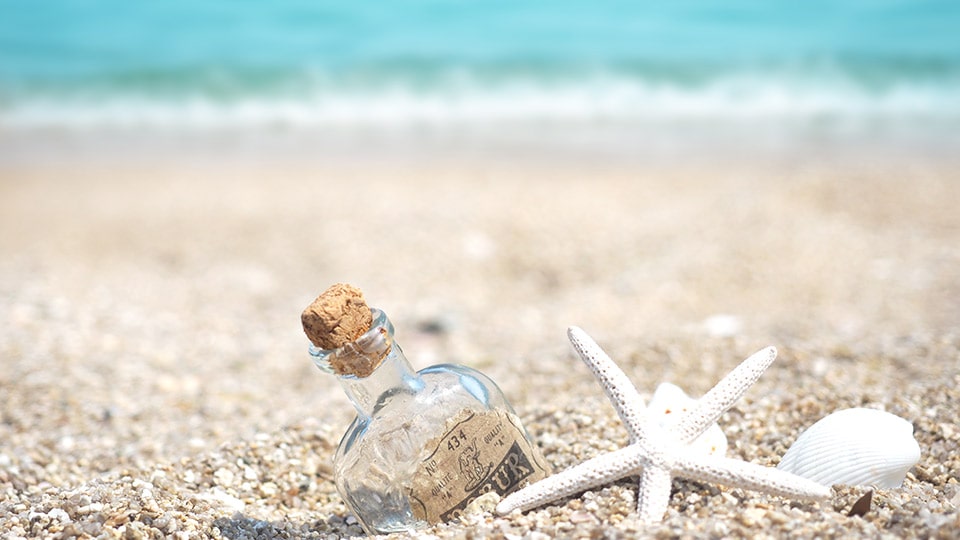 砂浜の小瓶と貝殻