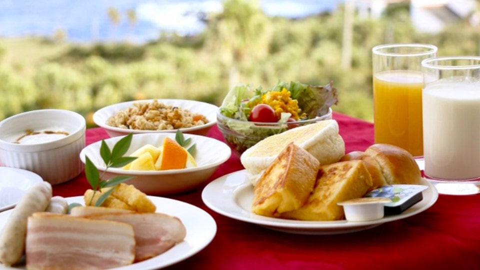 リードパークリゾート八丈島の朝食の一例（フレンチトースト、サラダ、牛乳、ジュースなどがたくさんテーブルに並ぶ様子）