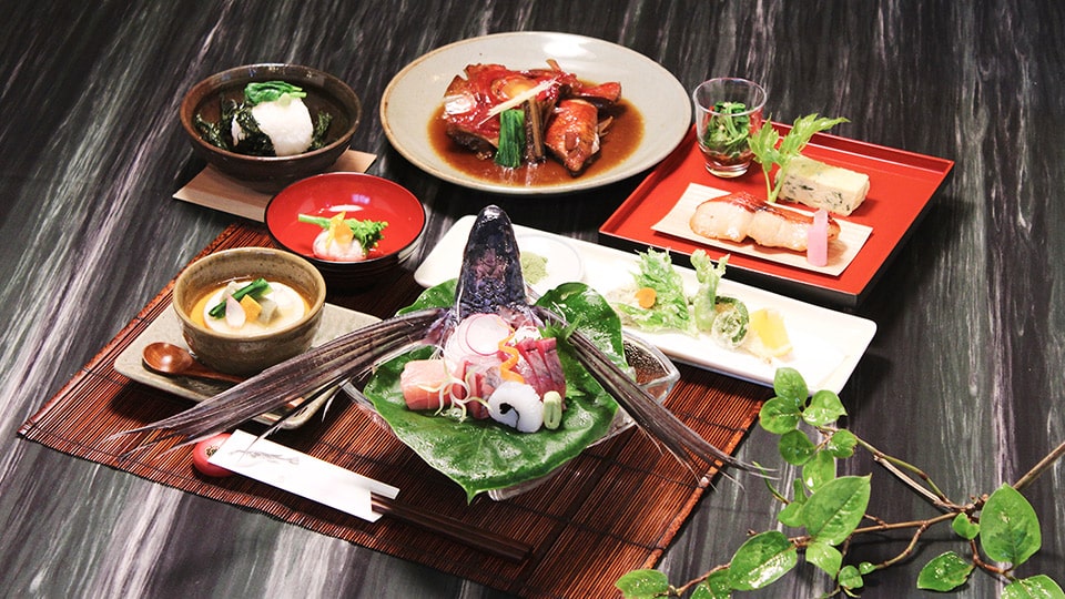 プチホテル満天望の夕食の一例（刺身の盛り合わせ、魚の煮付け、小鉢など）