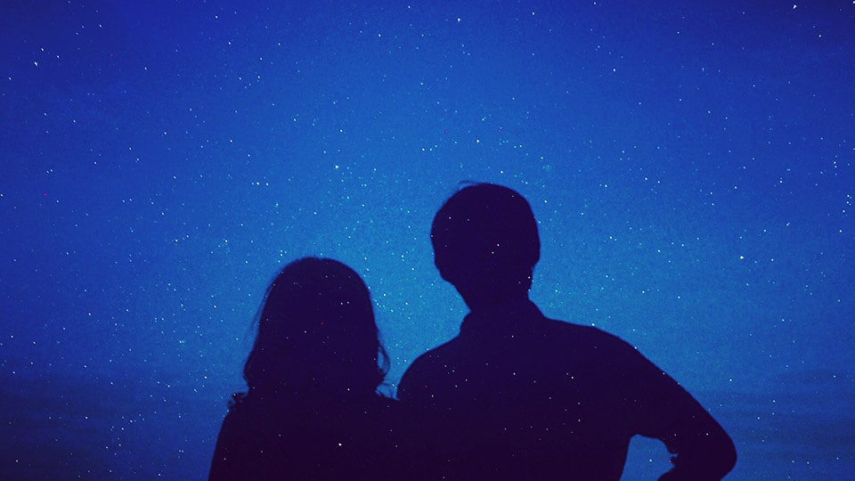 星降る空の下の二人のシルエット