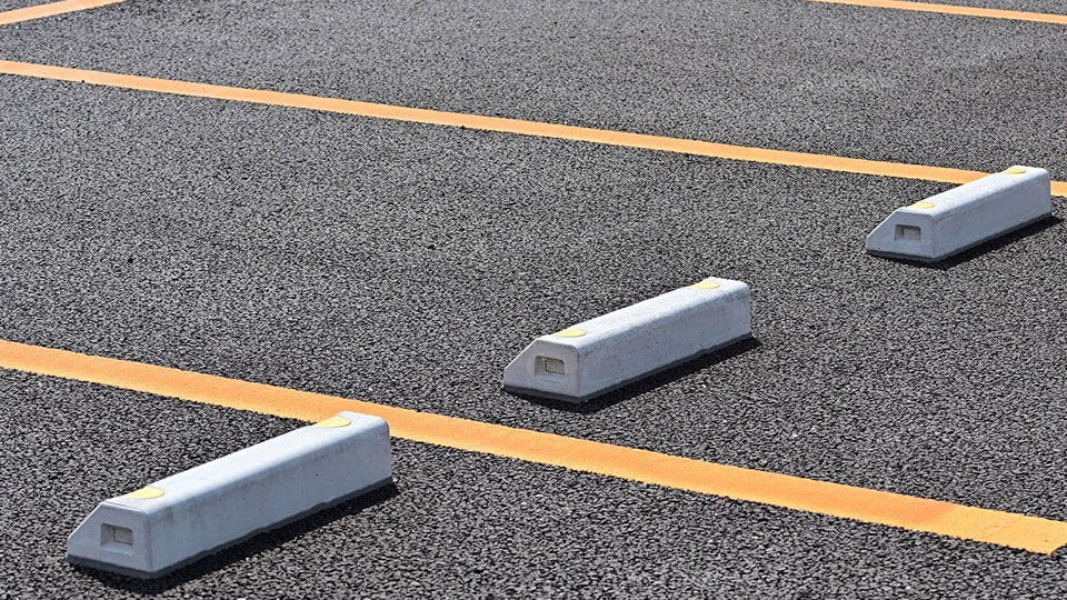 黄色いラインと車止めの駐車場イメージ