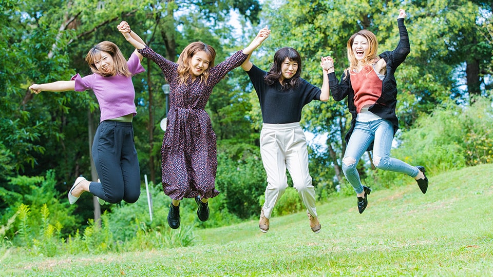 草むらでジャンプしている数人の女子