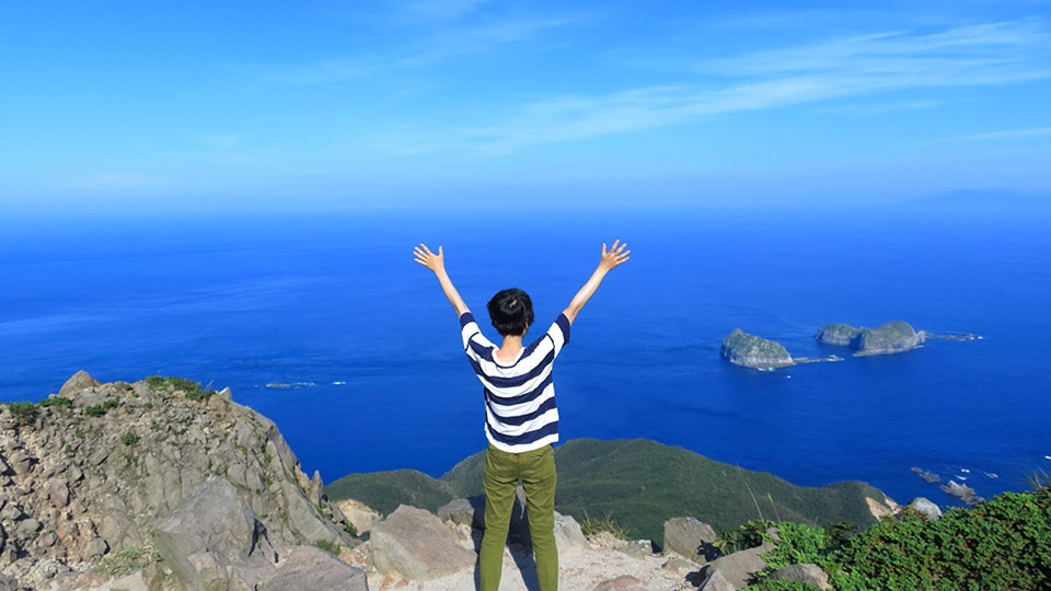 天上山の絶景の頂上でバンザイをしている様子