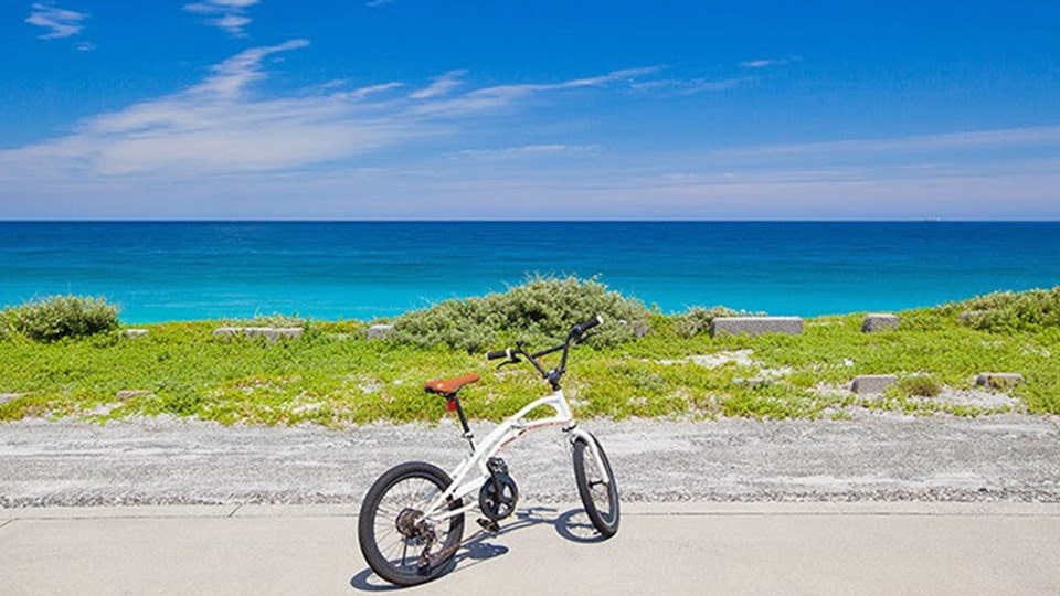 新島の海の景色をバックにレンタサイクルを停車